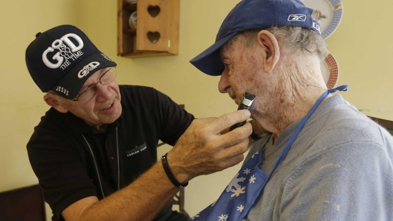 Warren Manchess, 74, shaves Paul Gregoline during a visit as...