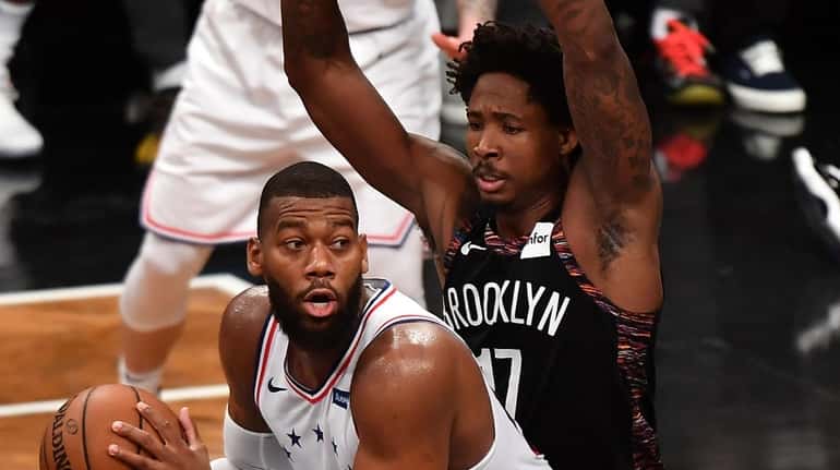 76ers center Greg Monroe is defended by Nets forward Ed...
