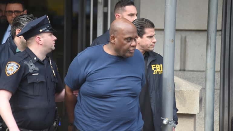 Alleged subway shooter Frank R. James is led out of...