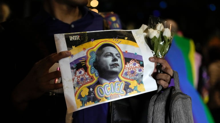 A demonstrator holds a picture of Aguascalientes state electoral court...