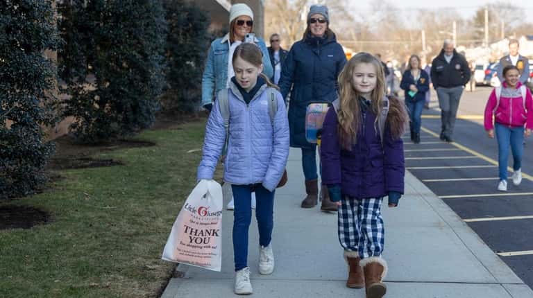 Michelle Eslinger walks with her daughter Kennedy, 9, and Ann...