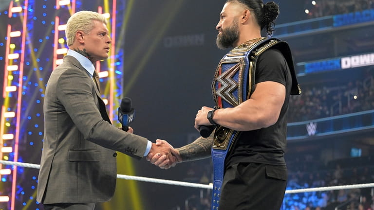 Cody Rhodes, left, and Roman Reigns meet in the center...