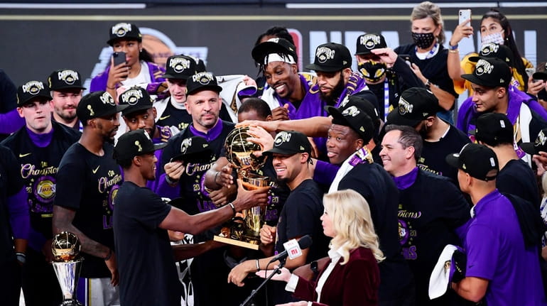 The Los Angeles Lakers celebrate with the trophy after winning...