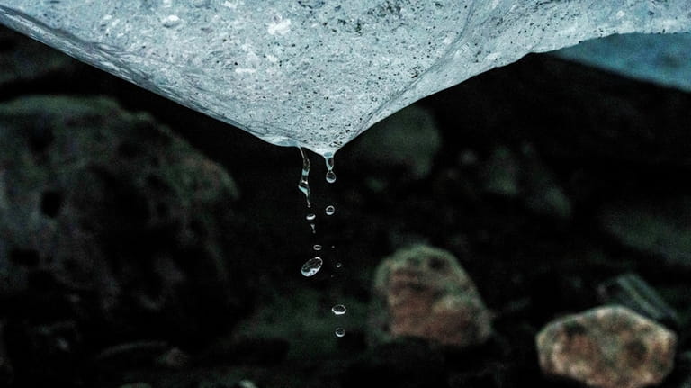 Water drips from a melting chunk of ice that originated...