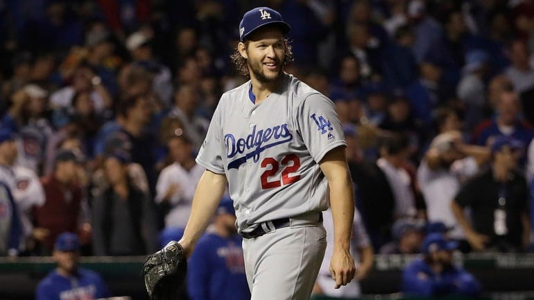 Los Angeles Dodgers starting pitcher Clayton Kershaw reacts as he...
