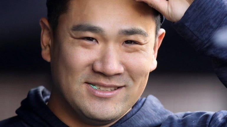 Masahiro Tanaka of the Yankees looks on from the dugout...