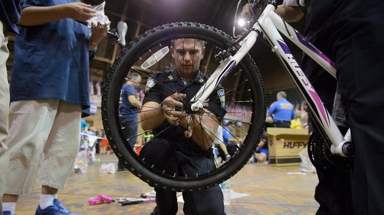 Port Authority Police Officer Liam Huczko assembles a bicycle during...