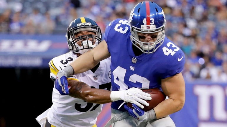 Giants running back Shane Smith tries to break a tackle...