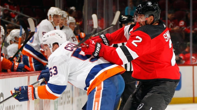 Brendan Smith of the Devils checks Casey Cizikas of the Islanders during the...