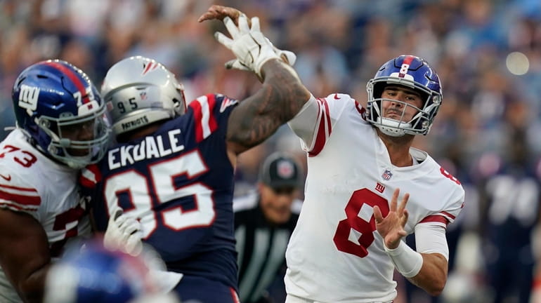 Giants quarterback Daniel Jones throws a pass over Patriots defensive tackle...