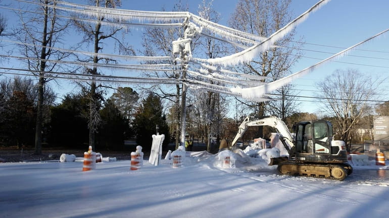 Ice covers power lines and the street after a high-pressure...