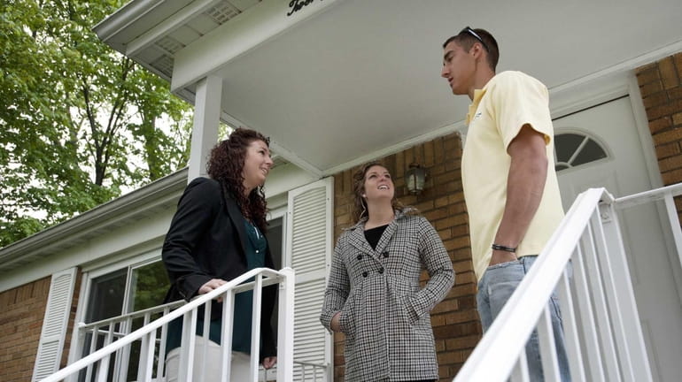 Realtor Courtney Dunford, center, shows a home to first home...