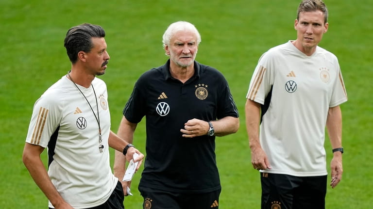 Germany's then interim coaches Rudi Voeller, center, Hannes Wolf, right,...