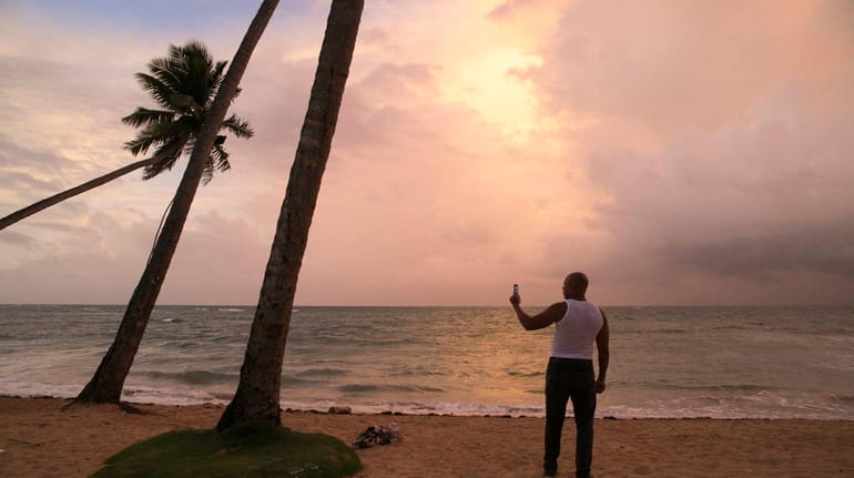 A man stands on the beach in Las Terrenas, Dominican...