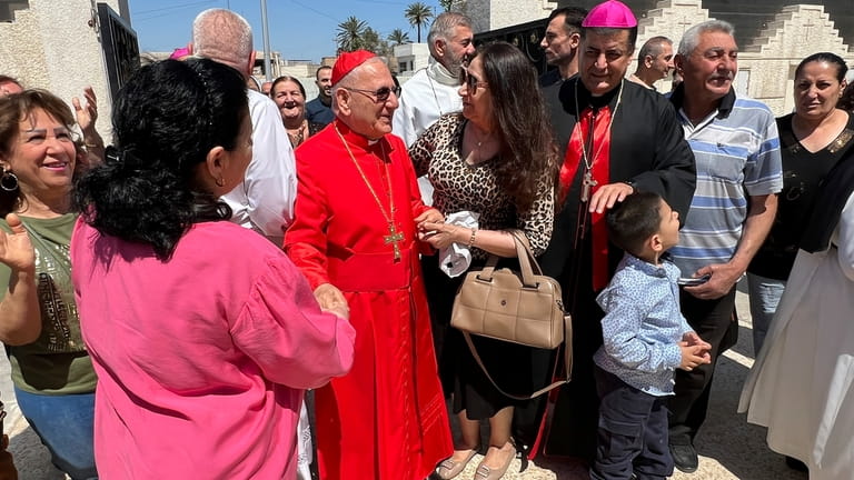 Chaldean Patriarch Louis Sako greets parishioners after a mass following...