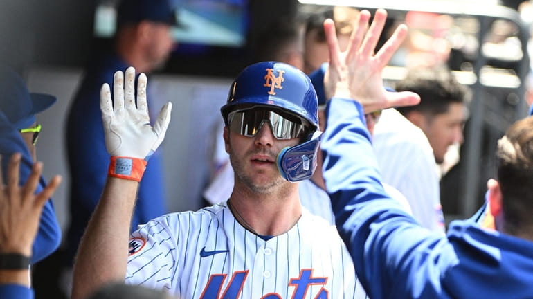 New York Mets' Pete Alonso is greeted in the dugout...