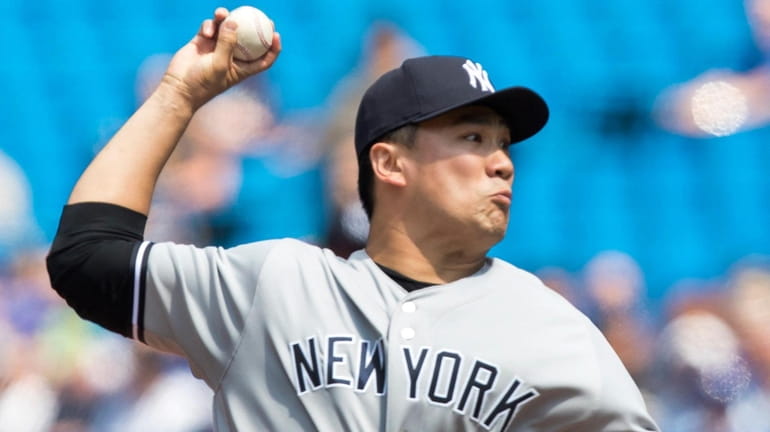 Yankees starting pitcher Masahiro Tanaka delivers against the Blue Jays...