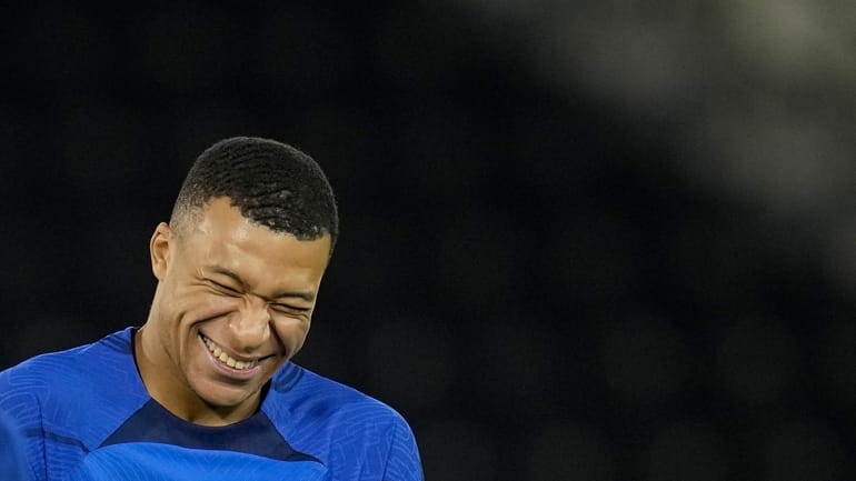 France's Kylian Mbappe jokes during a training session at the...