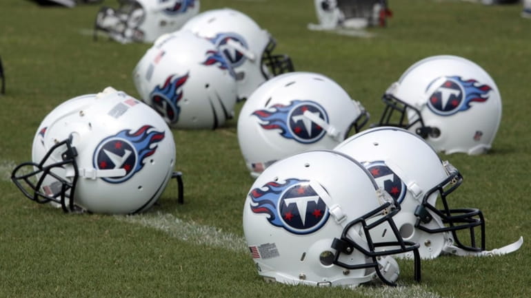 Tennessee Titans helmets sit on the field during football practice...