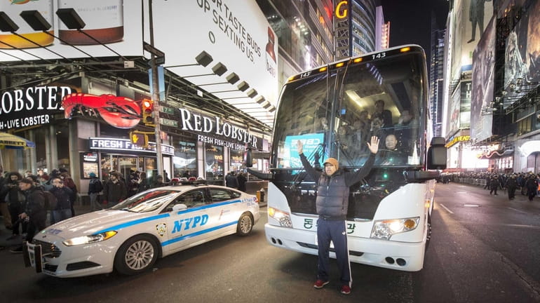 Marvin Day, of Jackson Heights, holds up a large bus...