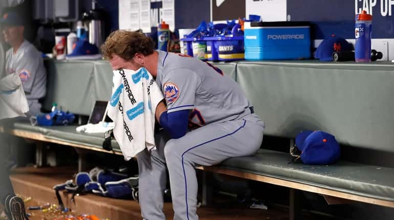 New York Mets relief pitcher Drew Gagnon wipes his face...
