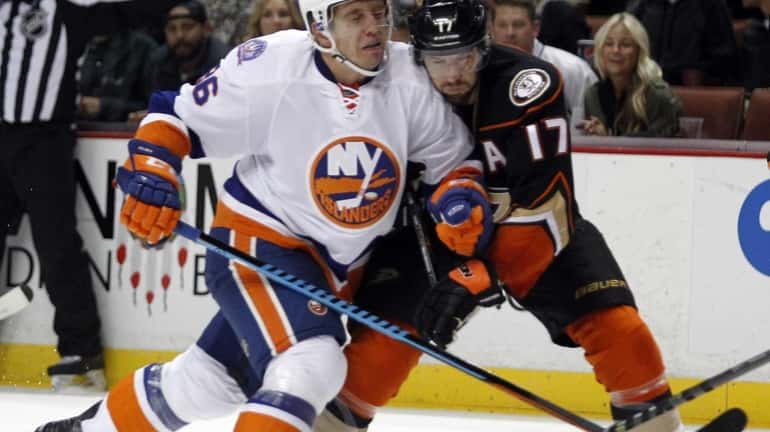New York Islanders left wing Nikolai Kulemin, left, collides with...