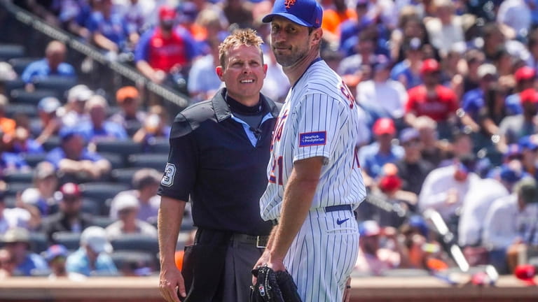 New York Mets starting pitcher Max Scherzer looks back while...
