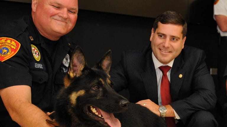 Then-Suffolk County Police Commissioner Tim Sini, with Officer Thomas Teufel,...