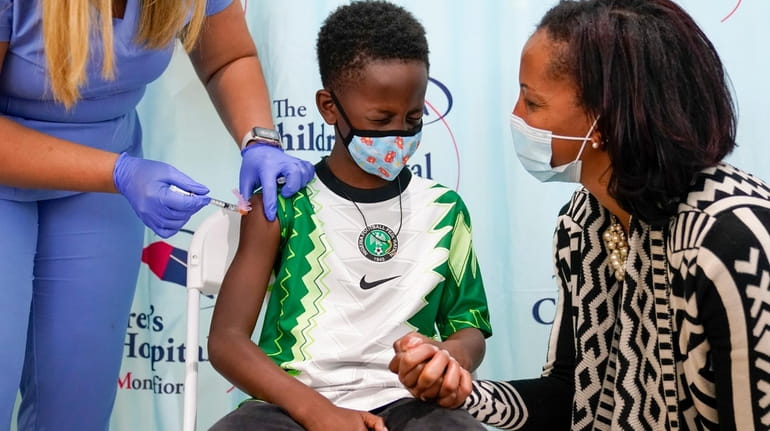 Dr. Rhonda Achonolu comforts her son Amechi, 7, as he...