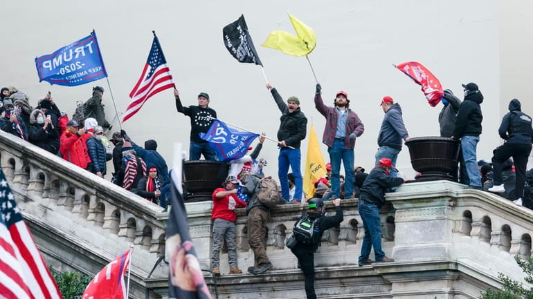 Rioters wave flags on the West Front of the U.S....