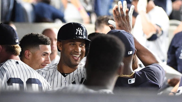Yankees centerfielder Aaron Hicks is greeted in the dugout after...