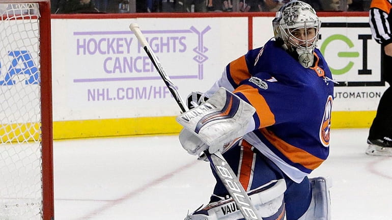 Islanders goalie Thomas Greiss stretches for the puck on Nov....