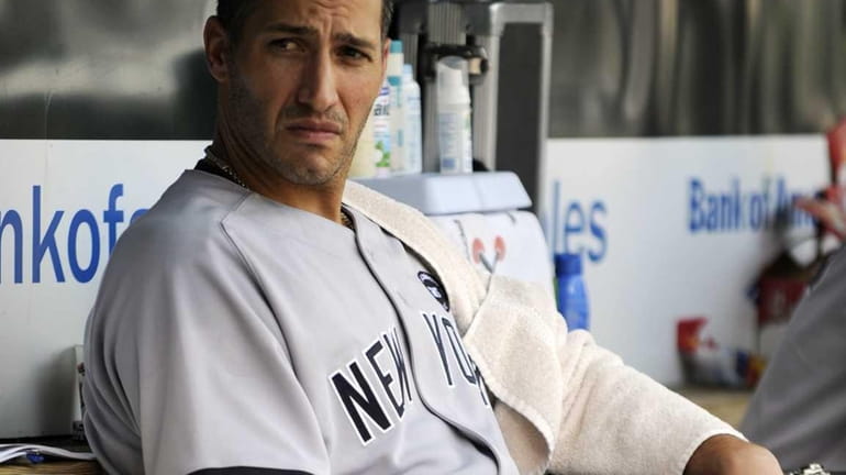 New York Yankees pitcher Andy Pettitte sits in the dugout...
