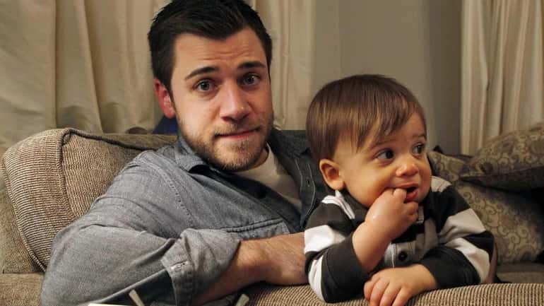Chris Illuminati, 33, sits with his one-year-old son Evan in...