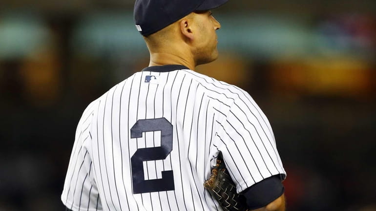 The Yankees' Derek Jeter walks to his position after the...