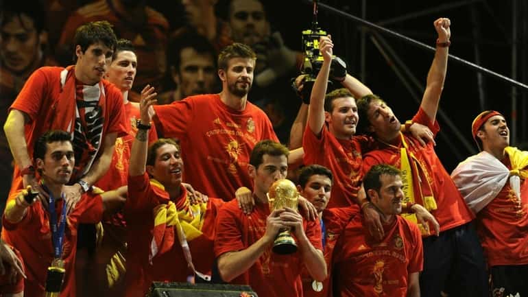 Spain's goalkeeper Iker Casillas, center, kisses the trophy as the...