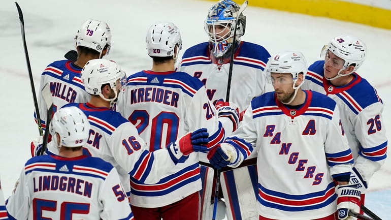 New York Rangers goaltender Igor Shesterkin, top, celebrates with teammates...