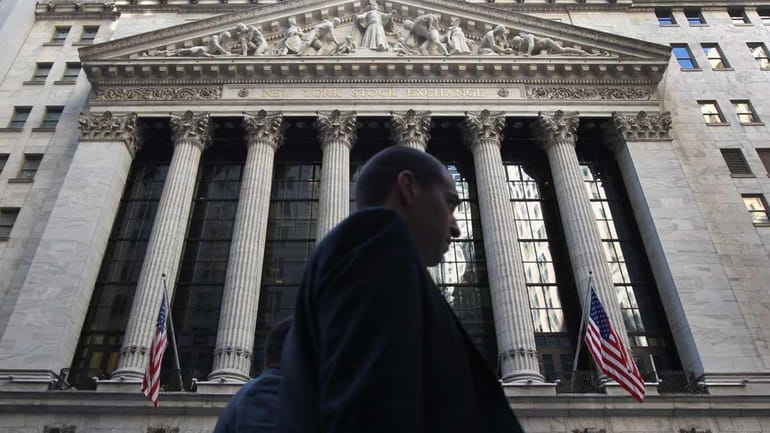 Pedestrians pass the New York Stock Exchange on Tuesday, May...