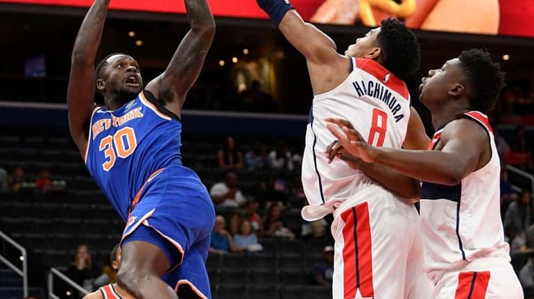 Knicks center Julius Randle goes to the basket against Wizards...