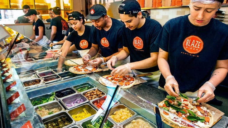 Pizza is an assembly-line production at Blaze Pizza.