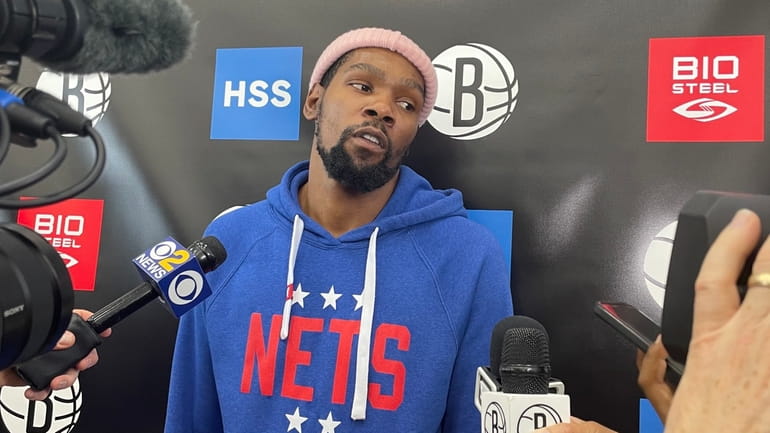 Injured forward Kevin Durant talks to reporters at Nets practice...