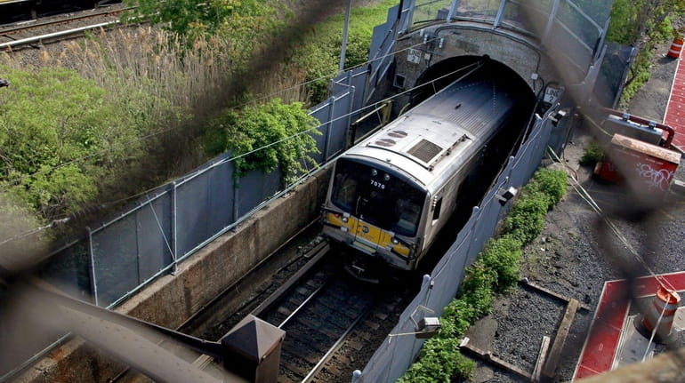 An LIRR train disappears into the East River Tunnel, travelling...