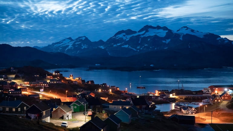 Homes are illuminated after the sunset in Tasiilaq, Greenland, Friday...