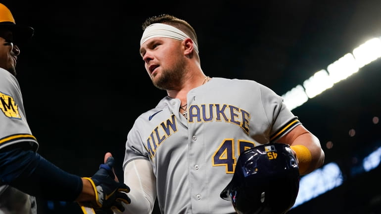 Milwaukee Brewers' Luke Voit is greeted by a teammate after...