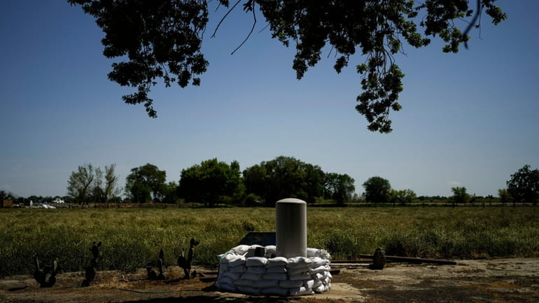 Sandbags are stacked around a well in anticipation of flooding...
