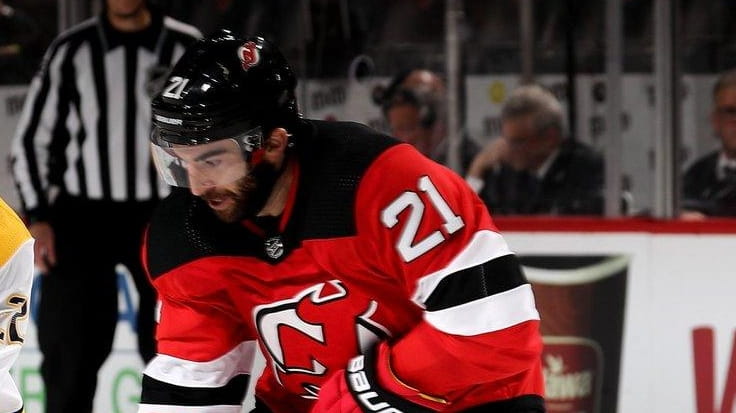 Kyle Palmieri #21 of the New Jersey Devils tries to...