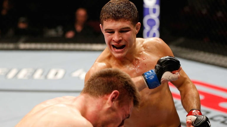 Al Iaquinta, right, punches Piotr Hallman in their lightweight bout...