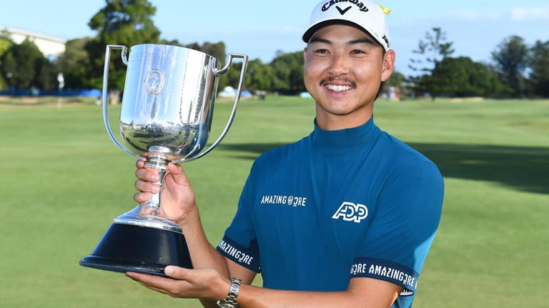 Australia's Min Woo Lee holds his trophy after winning the...