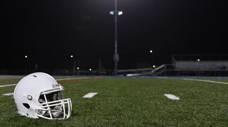 A white football helmet illuminated by floodlights at Oceanside's field...