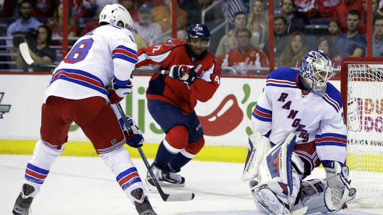 Rangers defenseman Marc Staal, left moves to clear the puck...